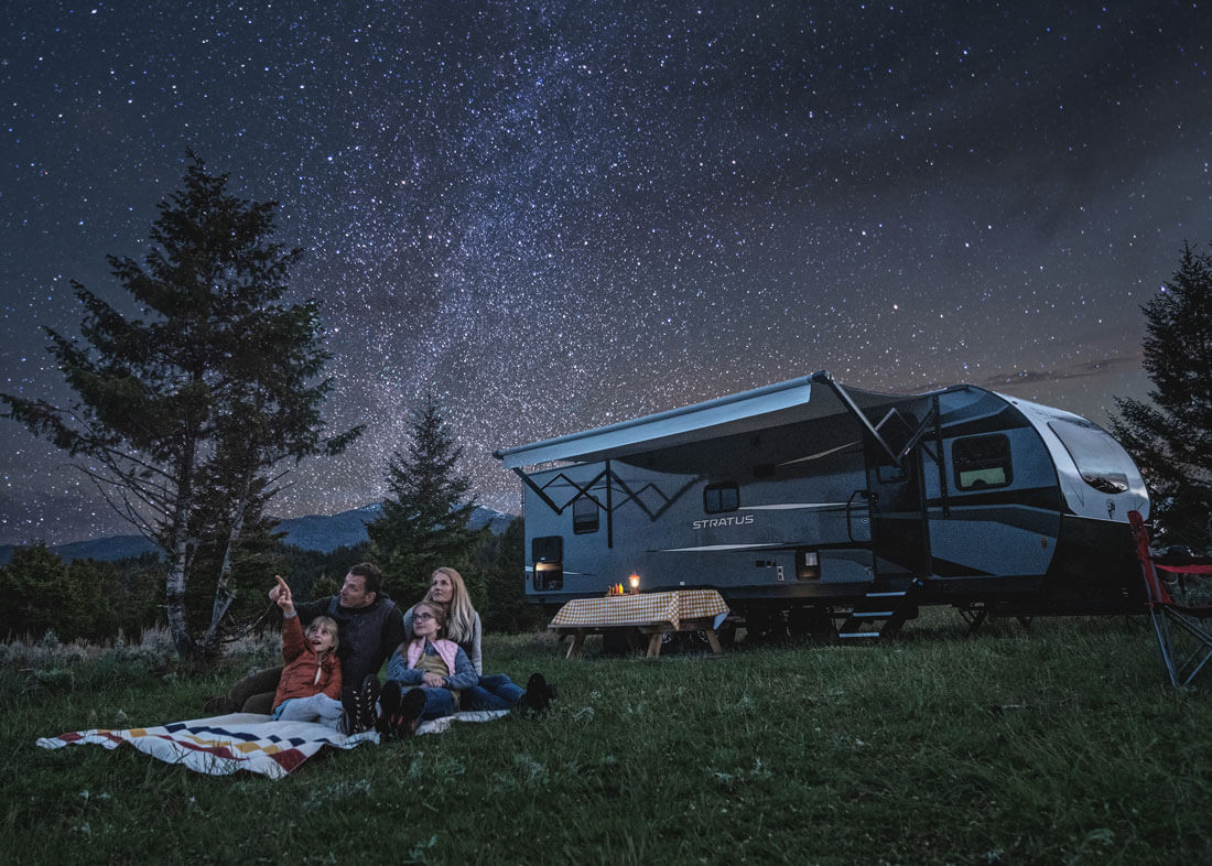 Une famille observant les étoiles devant leur Roulotte.