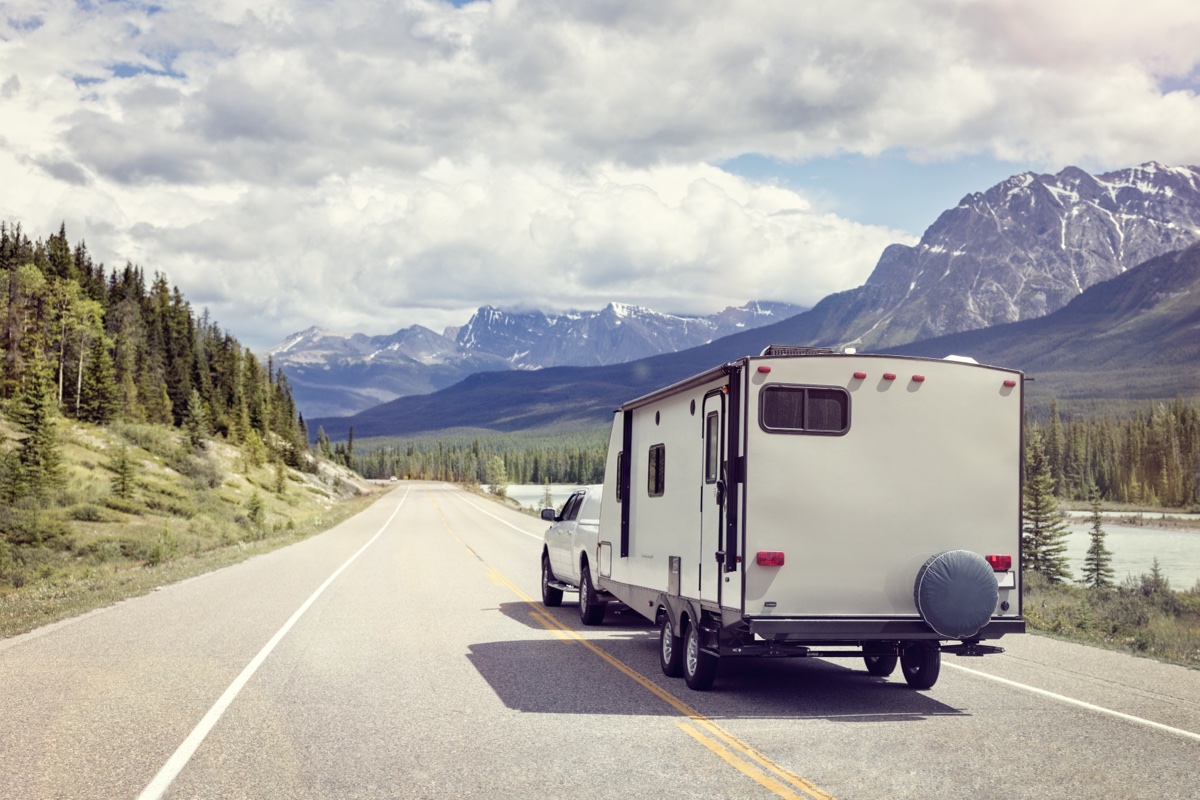 Vue arrière d'une roulotte qui s'en va en camping.